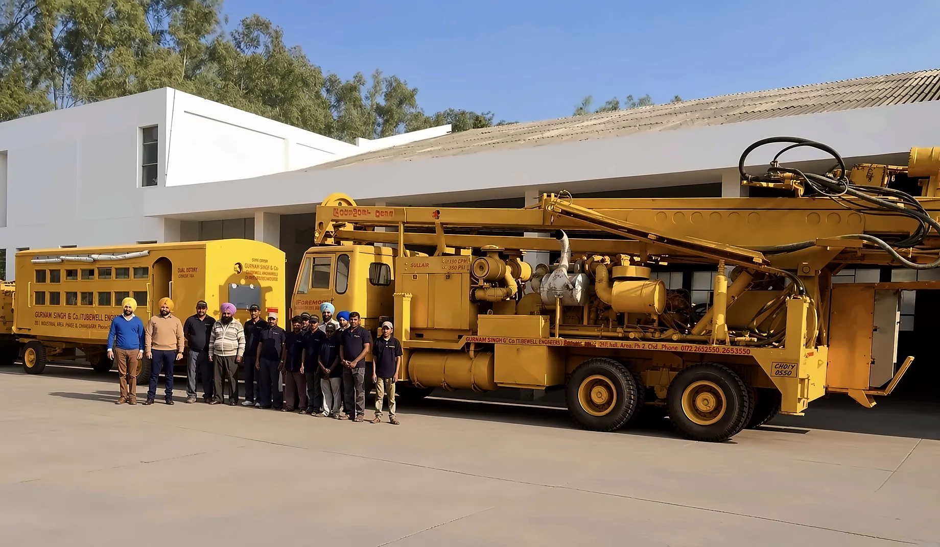 The Gurnam Singh and Company crew lined up beside the Foremost Dual Rotary rig and the compressor unit at Chandigarh