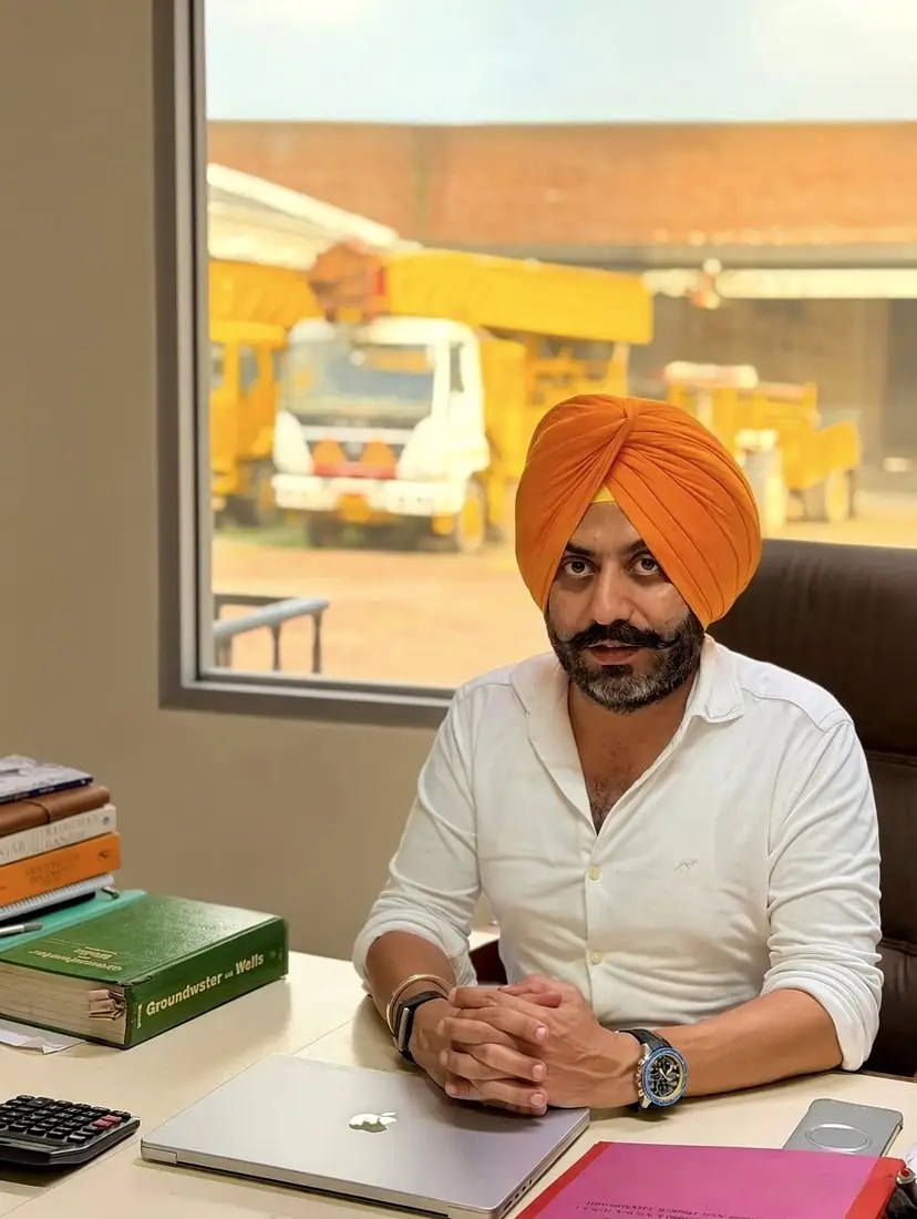 Amandeep Singh Saini at his desk at the Chandigarh works, rigs visible through the window