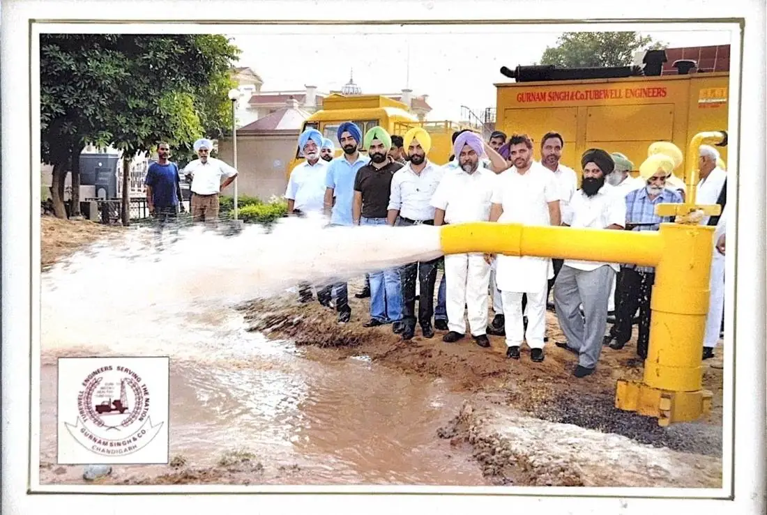 A completed tubewell in full discharge with the community watching