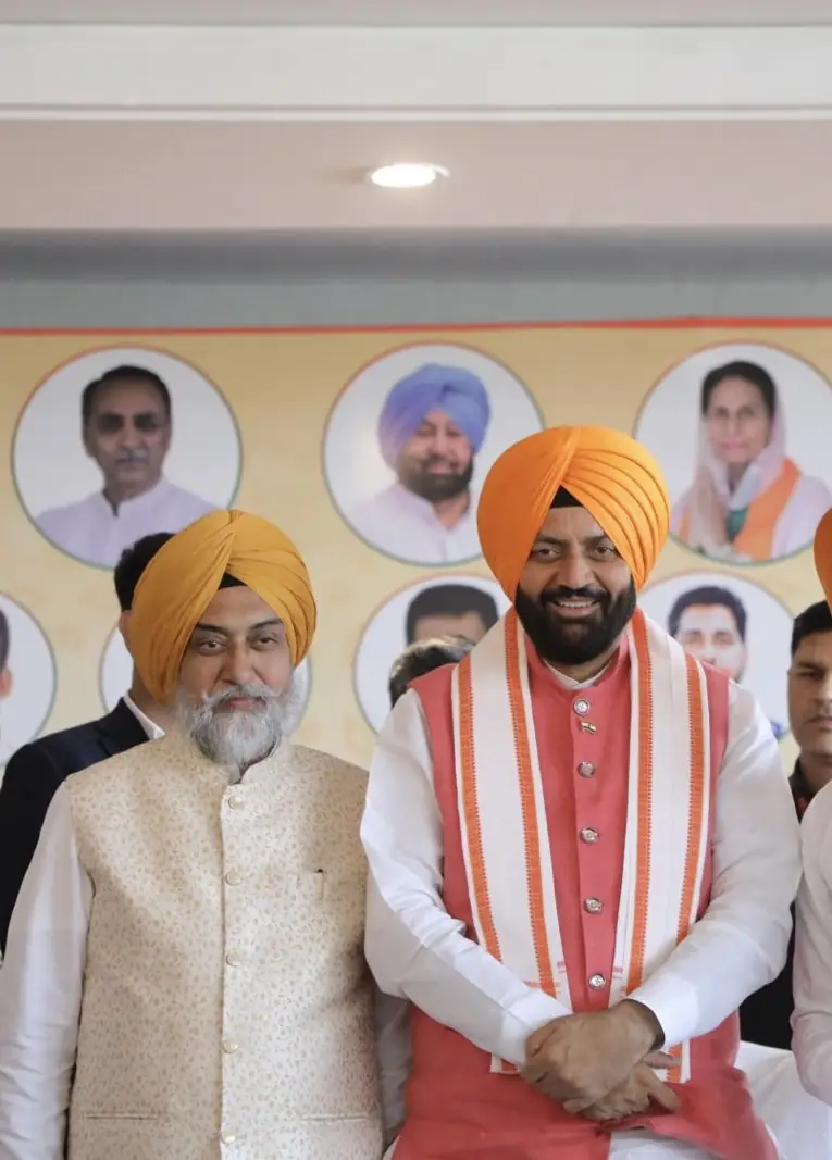 Shri Nayab Singh Saini raising the hand of Sardar Gurdarshan Singh Saini at the induction